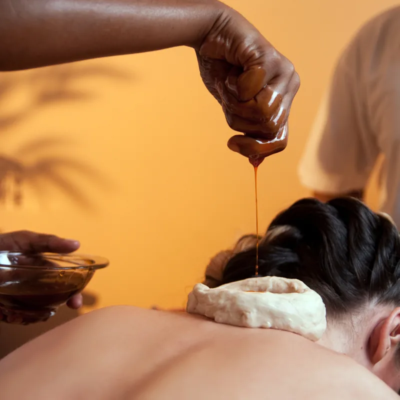 Warm herbal oil during an Ayurvedic therapy