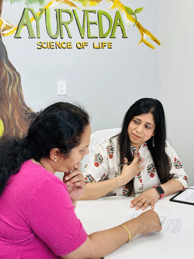Preeti Gupta in consultation with a client at her desk