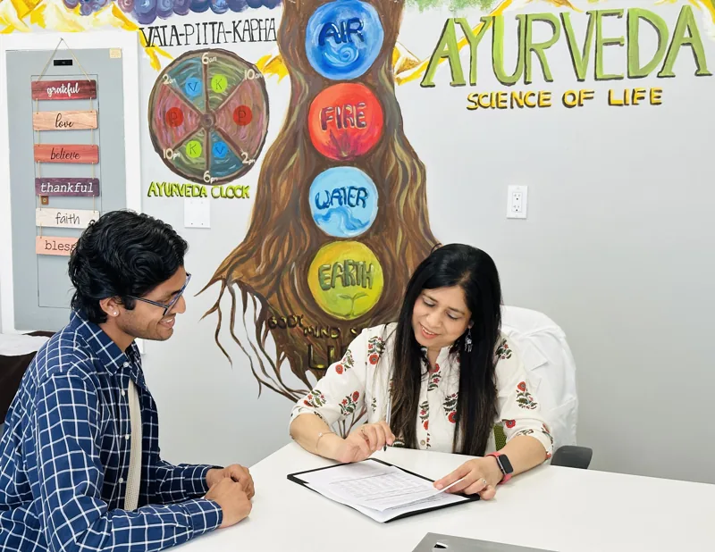 Preeti Gupta talking with a client at the clinic desk